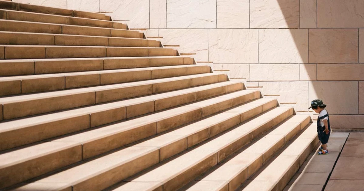 a kid trying to climb up the stair